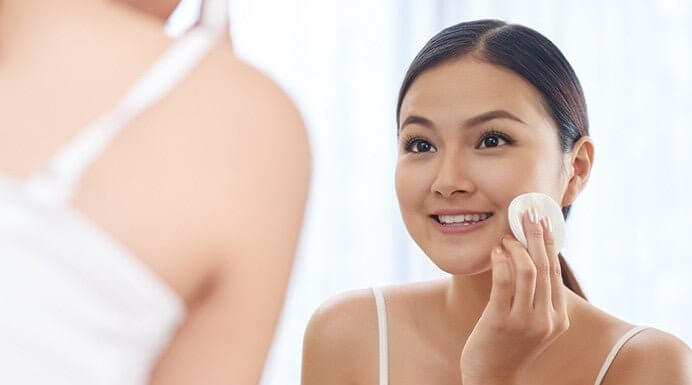 Woman applying MD® Skin Balancing Solution with gauze – clarifying toner for acne-prone and sensitive skin