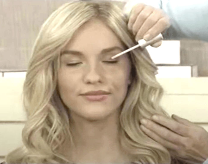 Smiling young blonde woman receiving MD Lash Factor Eyelash Conditioner application – lifestyle photo showing safe, precise lash serum use by MD Lash